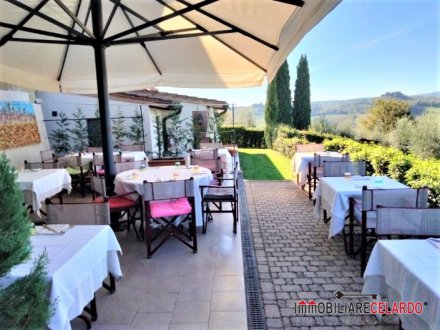 Restaurant surrounded by greenery with a view of the towers of San Gimignano